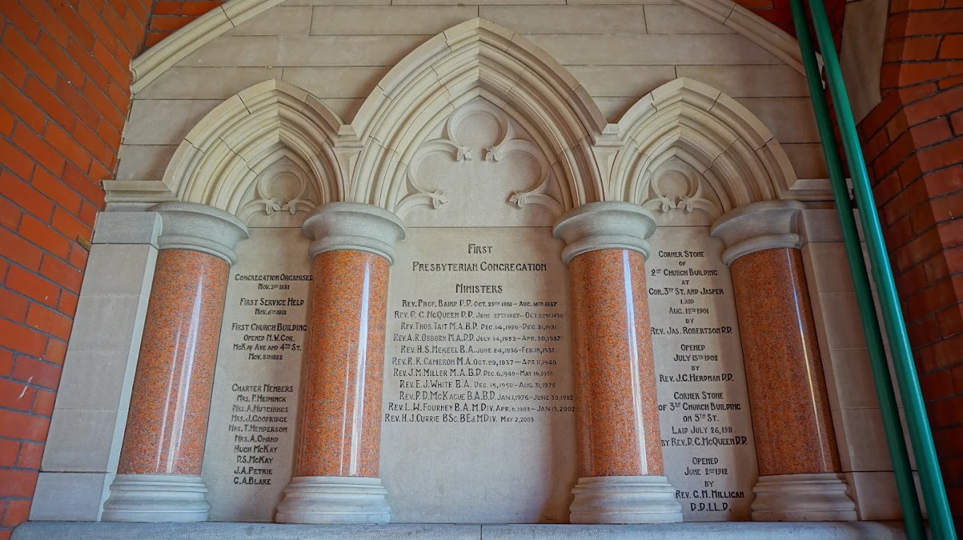 A carved stone plaque inside First Presbyterian Church recording the congregation's founding in 1881 and its ministers through the years